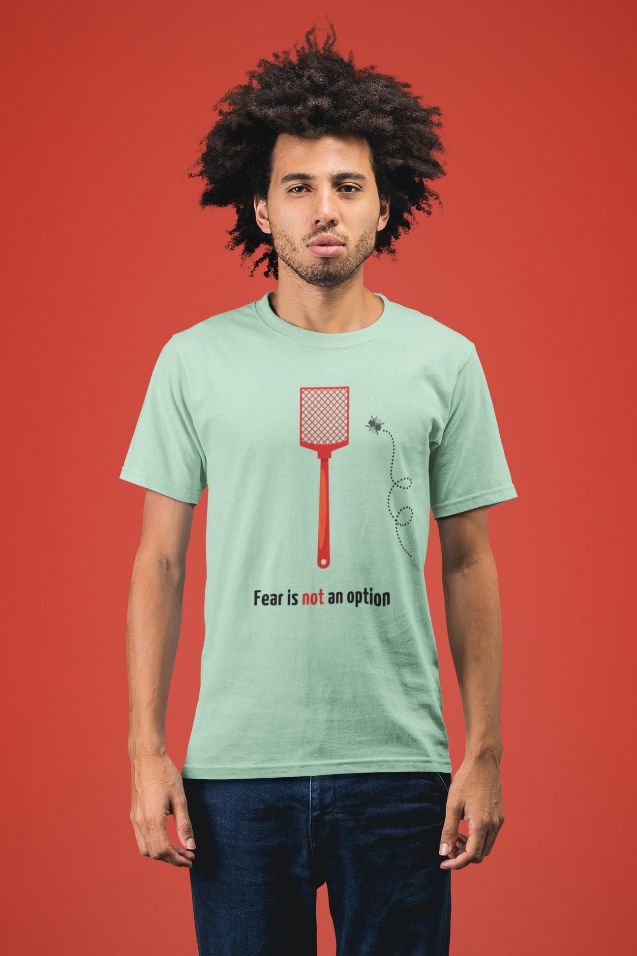"Fear is not an option". Opvallend shirt met een dappere vlieg die het opneemt tegen een vliegenmepper. 100% biologisch katoen. Kleur: Misty Jade